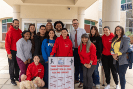 Group of people standing in front of hospital with sign