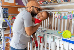 Father and baby bedside within a rehabilitation hospital