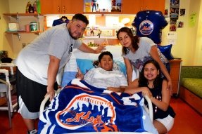family around bed with Mets gear 
