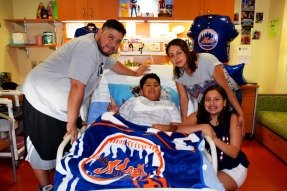family around bed with Mets gear