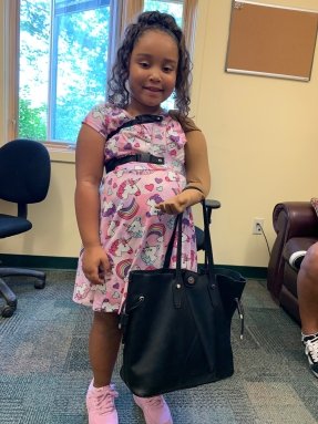 little girl with prosthetic arm and handbag