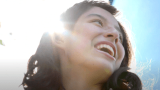 Teen girl smiling in bright sun