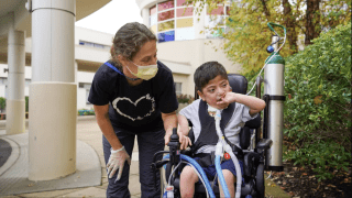 child with therapist outside of building