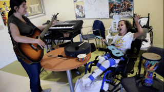 therapist and child playing music