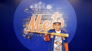 child in front of mets sign