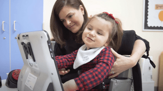 girl using augmentative communication device