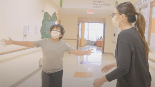 boy and female therapist walking down the hall