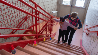 child and therapist walk up staircase