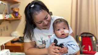 Photo of baby and mom looking at camera