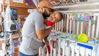 Father and baby bedside within a rehabilitation hospital
