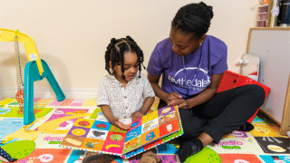 child with therapist reading a book