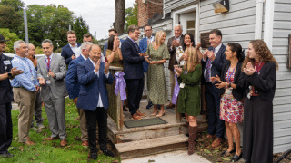 People gathered together for a ribbon cutting photo