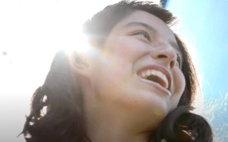 Teen girl smiling in bright sun