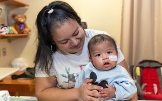 Photo of baby and mom looking at camera