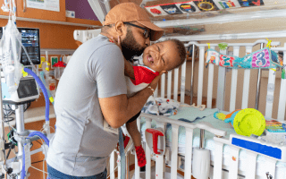 Father and baby bedside within a rehabilitation hospital