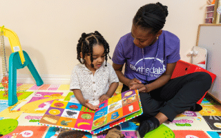 child with therapist reading a book