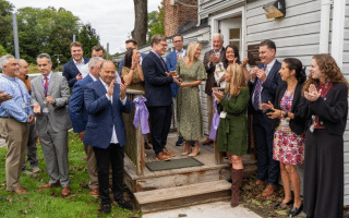 People gathered together for a ribbon cutting photo