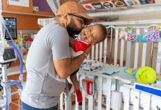Father and baby bedside within a rehabilitation hospital