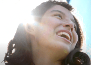 Teen girl smiling in bright sun