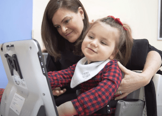 girl using augmentative communication device