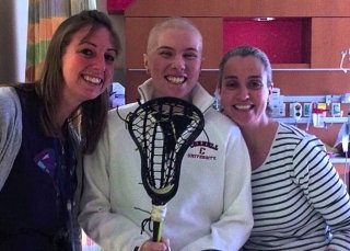 athlete with two women and lacrosse stick 