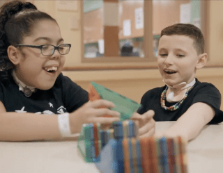 two children playing with magna tiles