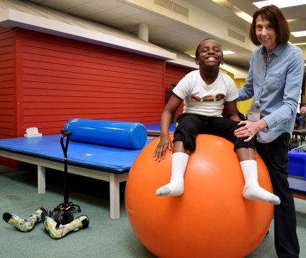 child sitting on ball smiling