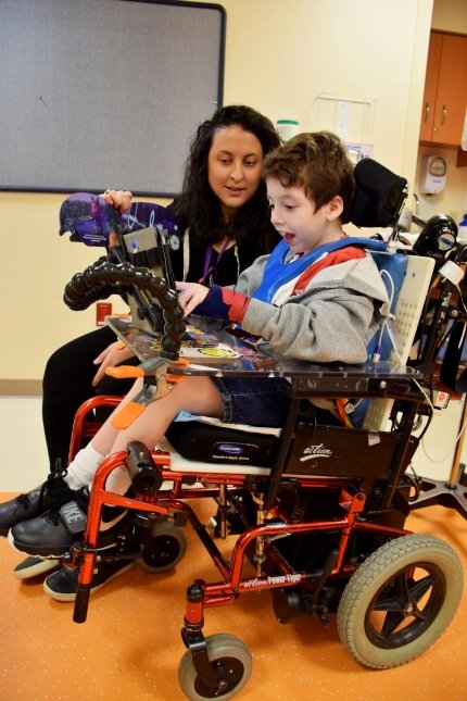 child in wheelchair and speech device