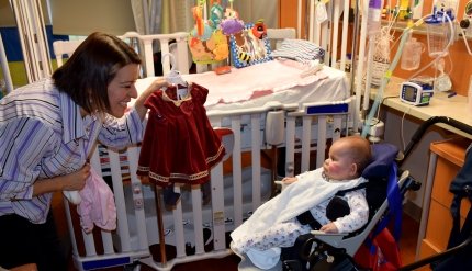 baby with clothing being shown to her