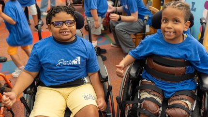 two boys in wheelchairs posing for a photo