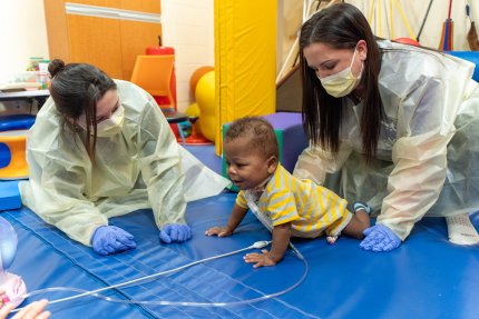child on mats during an occupational and physical therapy session