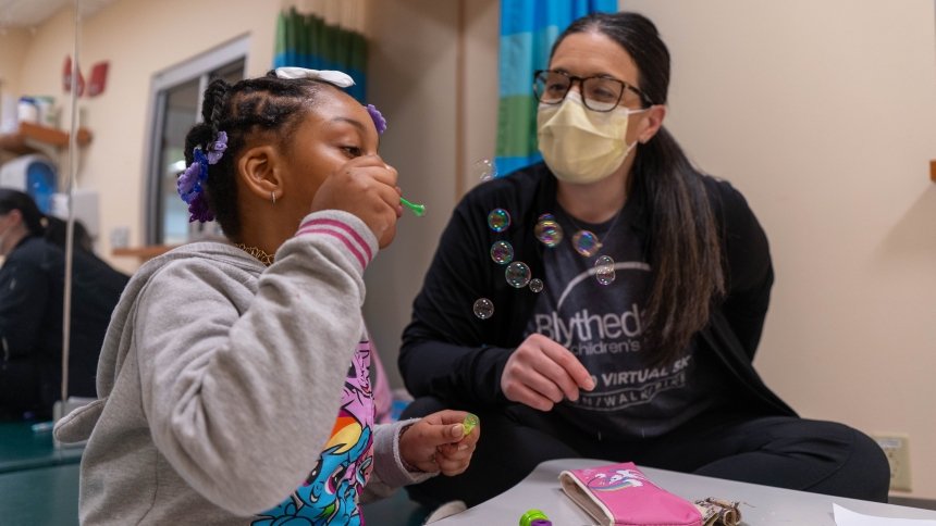 child blowing bubbles during a therapy session